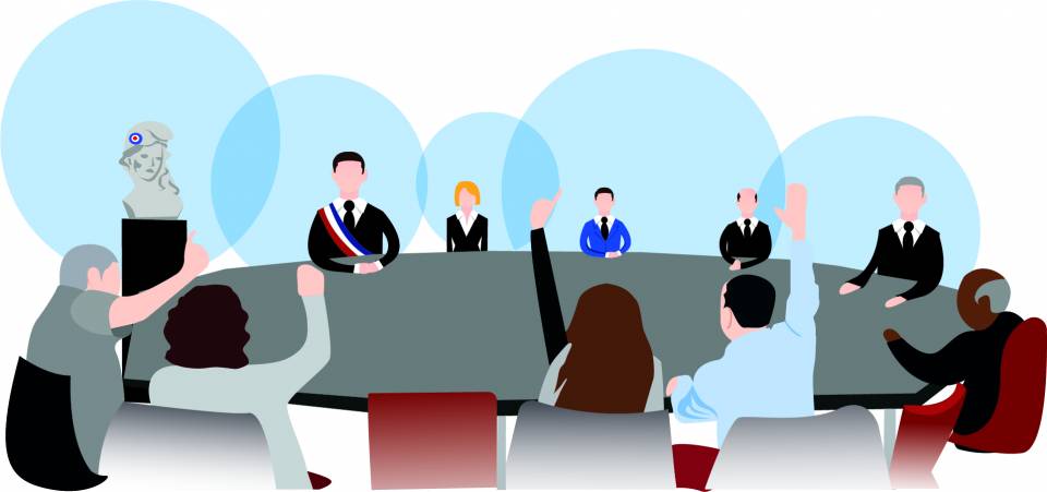 Élus installés autour d'une table ovale donnant un geste du pouce vers le haut lors d'une réunion.